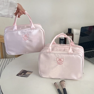 Detail of pink satin makeup bag with Lucky A embroidery and delicate bow design