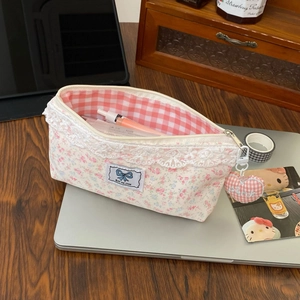 Detailed shot of floral lace pencil case with heart charm and pink checkered interior