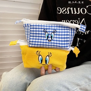 Close-up of bird embroidery on blue checkered and yellow corduroy pencil cases