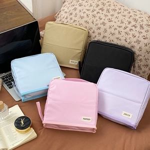 Detailed close-up of multiple macaron-colored toiletry bags arranged on a brown surface