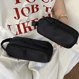 Detail of black multi-layer stationery pouch showing durable nylon fabric and zippers