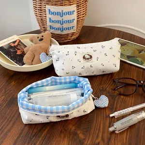 Floral cat pencil case with lace trim and heart charm on a wooden desk setup