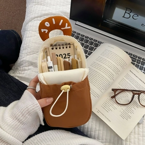 Detailed view of brown fabric pencil case with Jolly embroidery and 2025 mini calendar