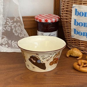 Detailed view of cream ceramic bowl with cute bear print and dark rim on lace cloth