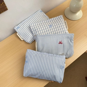 Detailed view of assorted bow-embroidered cotton makeup bags in stripes and plaid patterns