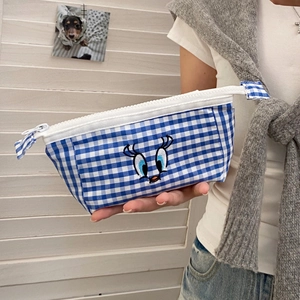 Close-up of blue and white checkered pencil case featuring cartoon eyes embroidery