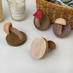 Close-up of cute wooden mushroom wall hooks in various wood tones and colors on a desk