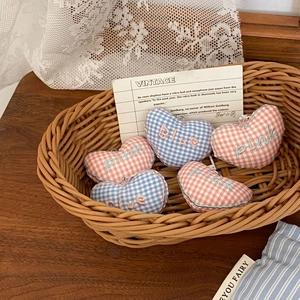 Detail of checkered heart charms with BLUE and PINK embroidery in a vintage basket