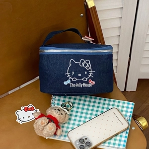 Close-up of the cat embroidery and Jolly House text on blue denim makeup bag