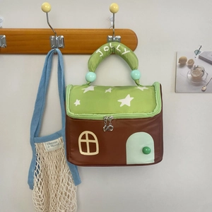 Detail view of the star-patterned roof and JOLLY embroidered handle on the house bag