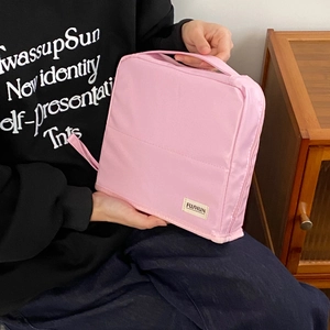 Pink portable nylon toiletry bag detail with widened handle and zipper closure