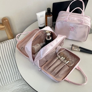 Pink satin cosmetic bag detail showing internal multi-compartment storage and PVC slots