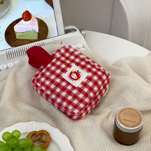 Detail of red checkered vanity bag with Hello Kitty patch and metal zipper closure