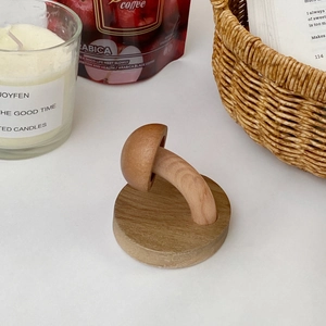 Detailed view of mushroom-shaped solid wood wall hook with natural grain and smooth finish