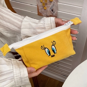 Detail of yellow corduroy stationery pouch featuring cute cartoon bird embroidery and zipper
