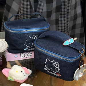 Detail of Hello Kitty denim makeup bag featuring cat embroidery and silver heart charm