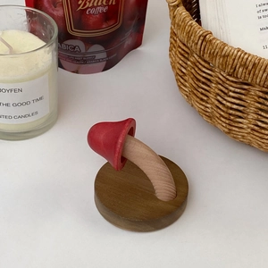Detail of red wooden mushroom wall hook on solid wood base in a cozy lifestyle setting