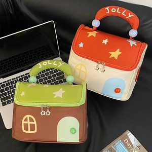 Detail of house-shaped makeup bags with JOLLY embroidery and star patterns