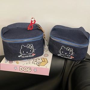 Detail of denim cosmetic bags with cat embroidery and sturdy metal chain accessories