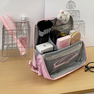 Pink large capacity travel makeup bag with brush slots on a warm wooden background