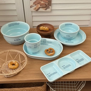 Vue détaillée du service de table en céramique bleu clair avec imprimés de lettres noirs