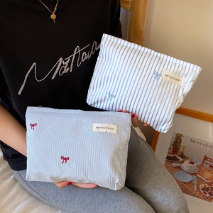 Close-up of striped makeup bags with bow embroidery and MEYOU FAIRY woven brand label