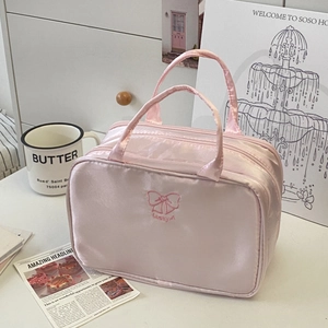 Close-up of pink satin makeup bag with Lucky Girl embroidery and double zipper detail