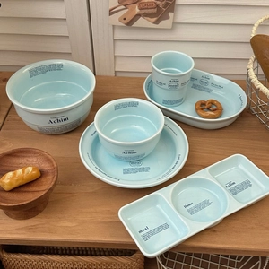 Gros plan d'un service de table en céramique bleu clair avec typographie noire élégante