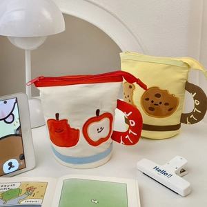 Detail of canvas pencil bags in mug shapes with cute apple and biscuit embroidery