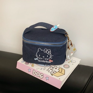 Close-up of denim cat makeup bag with embroidery and silver mini pouch accessory