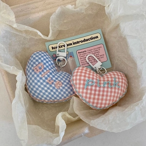 Detail of plaid heart keychains in pink and blue with embroidery in a gift box