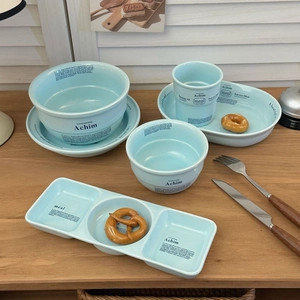 Service de vaisselle en céramique bleue avec texte sur table en bois rustique