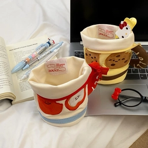 Detail of fabric pen holders with cookie and heart patterns on a cozy desk setup