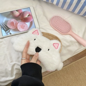 Detail of soft white plush Westie dog eye mask with cute embroidery in a basket