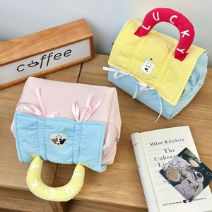 Detailed view of plush quilted cosmetic bags with lucky letter handles and cartoon embroidery