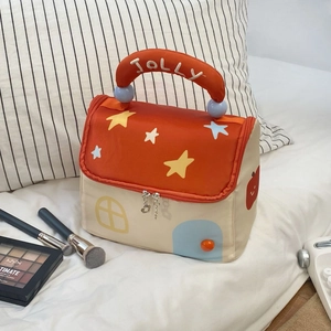 Detail of star house makeup bag with dual zippers, heart charm and JOLLY handle