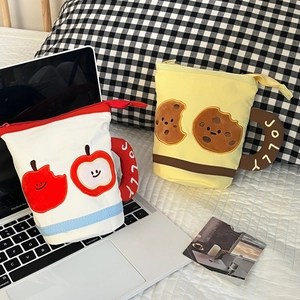 Detail of canvas pencil bags in mug shapes with apple and cookie embroidery patterns