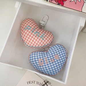 Detail of pink and blue plaid heart keychains with embroidered text and lobster clasps