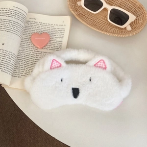 Close-up of cute white plush dog sleep mask with embroidered eyes and ears detail