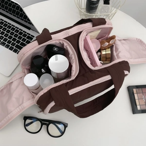 Macro view of double zip compartments in a quilted cosmetic bag for travel storage