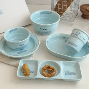 Détail d'un service de table en céramique bleu clair avec texte élégant et émail minimaliste