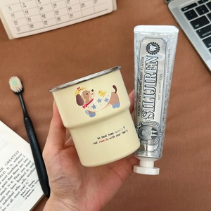 Close-up of cute dog illustration on cream toothbrush cup with toothpaste