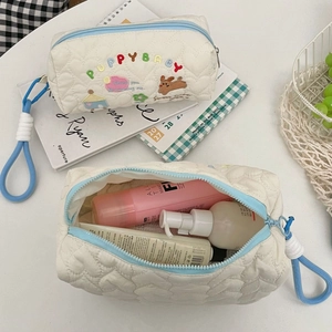 Internal view of a quilted puppy makeup bag showing spacious storage for skincare bottles