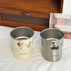 Detail of dachshund puppy stainless steel cups in cream and brushed metal finishes