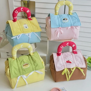 Close-up of quilted makeup bags with cute cartoon patches and Lucky printed handles