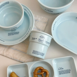 Gros plan sur un ensemble de vaisselle en céramique bleu clair avec texte noir décoratif