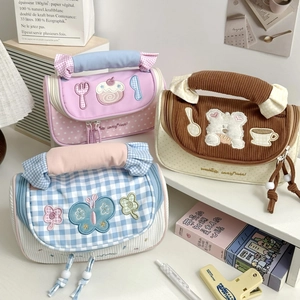 Detailed view of macaron color pencil cases with embroidery and thick padded handles
