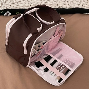 Detail of partitioned large makeup bag with mesh pockets and brush slots