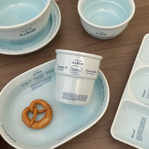 Service de vaisselle en céramique bleue avec typographie moderne et assiettes ovales
