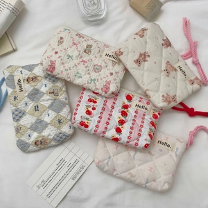 Detailed flat lay of quilted cotton mini pouches in various floral and bear patterns